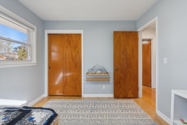 bedroom with light wood-style flooring and baseboards