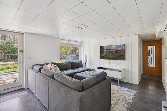 living area featuring concrete floors and wooden walls