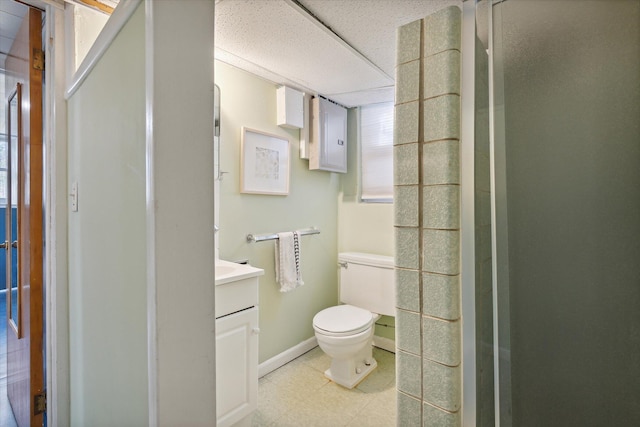 bathroom with a stall shower, vanity, toilet, and baseboards