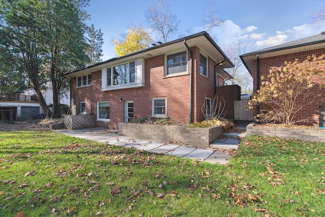 back of house with a patio area, a yard, and brick siding