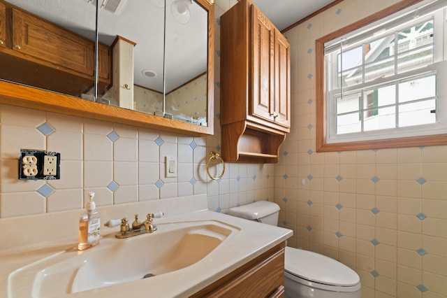 bathroom with visible vents, tile walls, toilet, and vanity