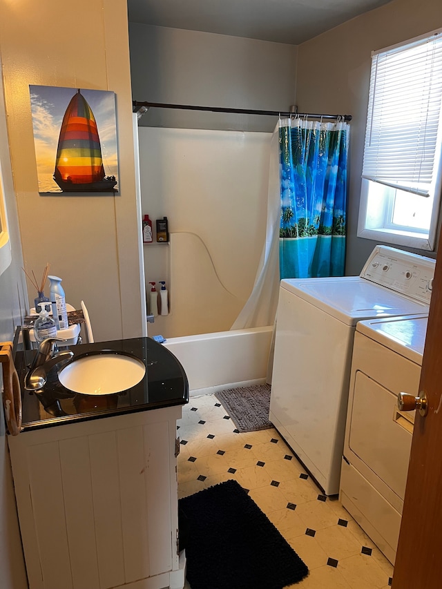 bathroom featuring washing machine and dryer, vanity, shower / tub combo with curtain, and tile patterned floors