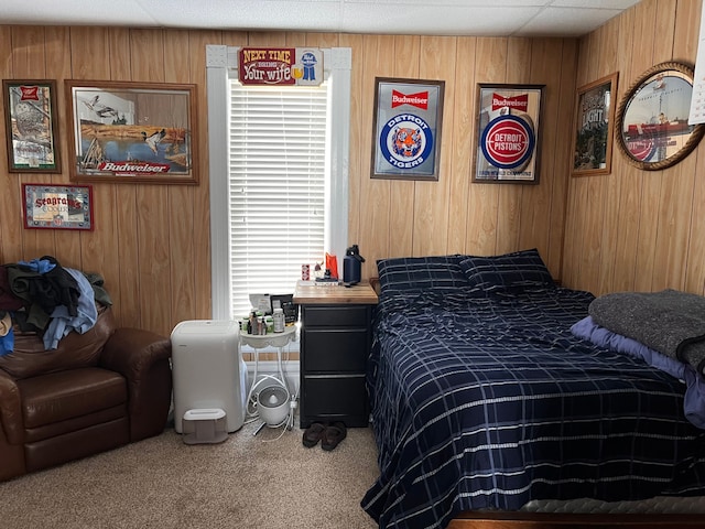 bedroom featuring wooden walls and carpet flooring