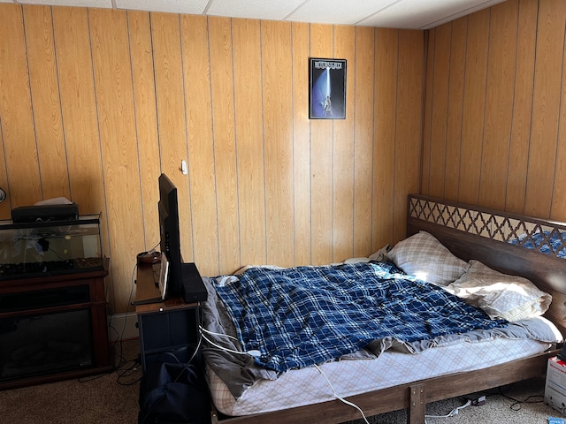 carpeted bedroom with wood walls