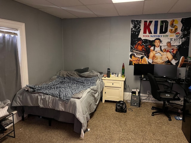 bedroom featuring a drop ceiling and carpet flooring