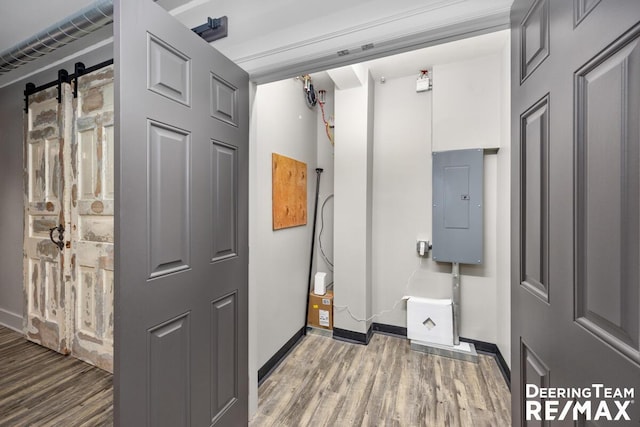 interior space featuring wood finished floors, electric panel, and baseboards