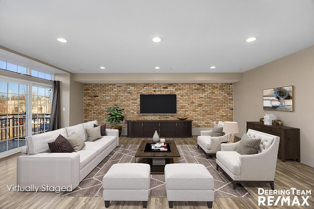 living room featuring brick wall, wood finished floors, and recessed lighting