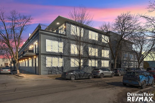 property exterior at dusk featuring stucco siding