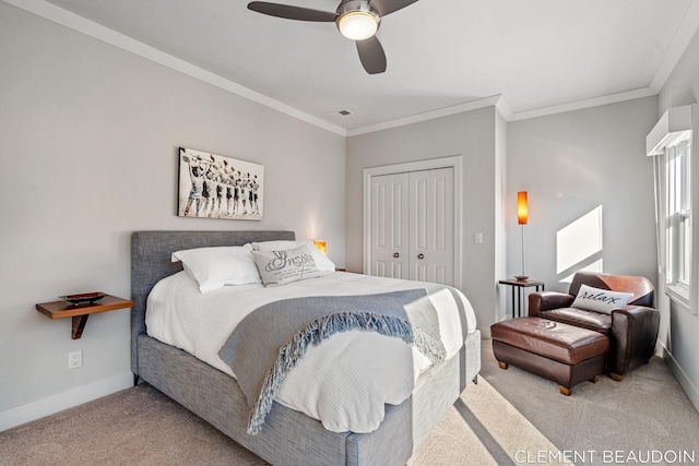 bedroom with a closet, carpet flooring, crown molding, and baseboards