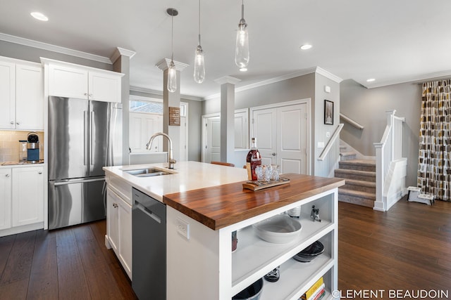 kitchen with stainless steel appliances, white cabinets, dark wood-type flooring, and a sink