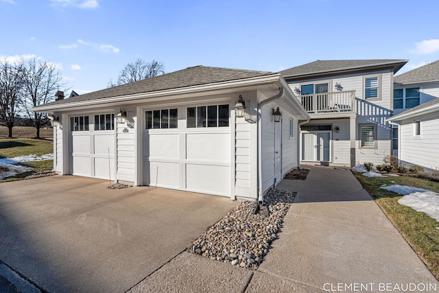 view of front of house featuring driveway, a garage, and an outbuilding