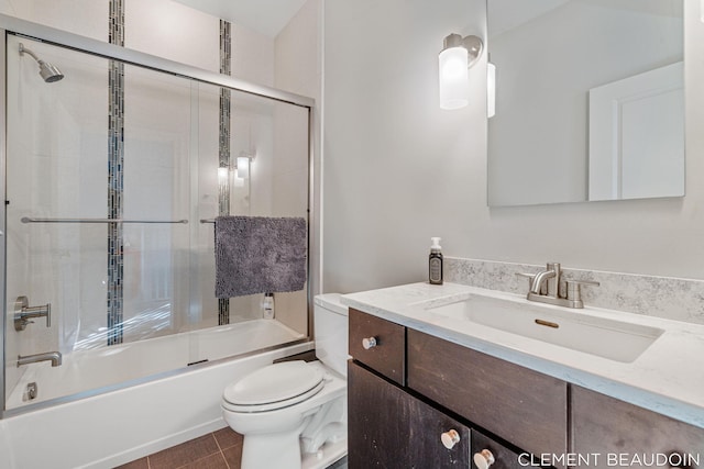 full bathroom featuring tile patterned flooring, enclosed tub / shower combo, vanity, and toilet