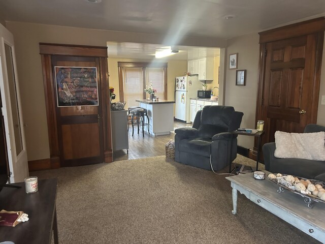 living area with light carpet and baseboards