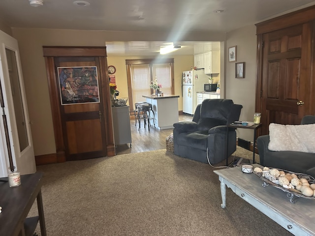 living room featuring light carpet and baseboards