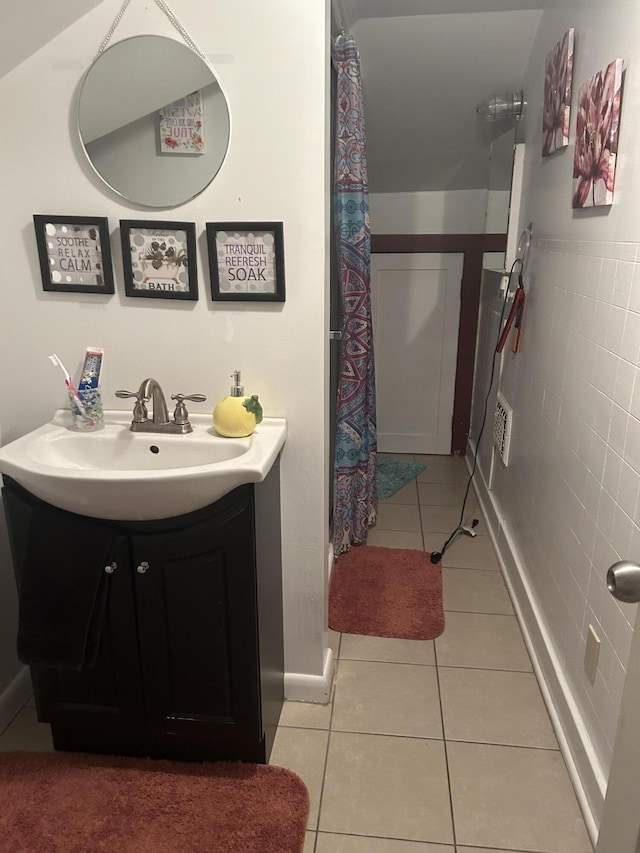 full bath featuring tile patterned flooring, curtained shower, vanity, and tile walls