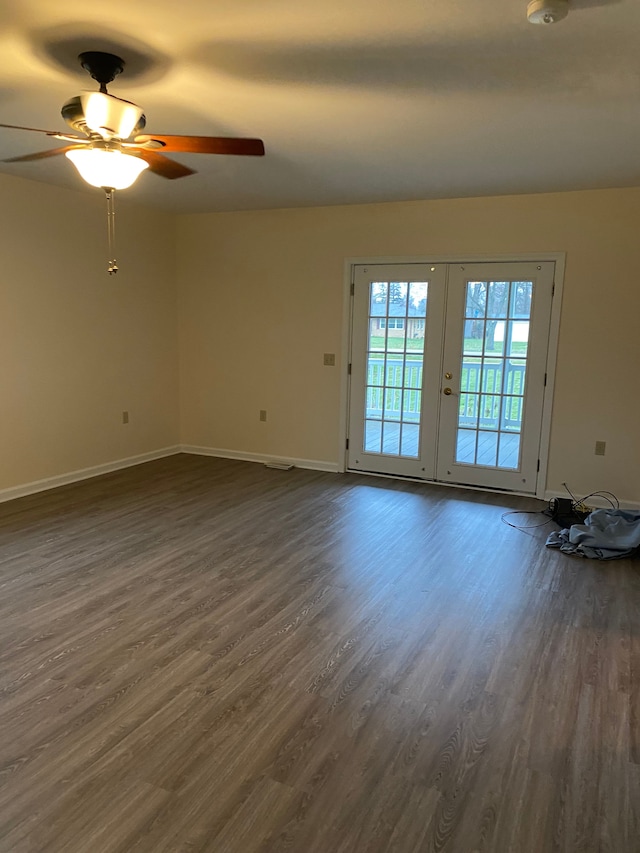 spare room with dark wood finished floors, baseboards, and ceiling fan