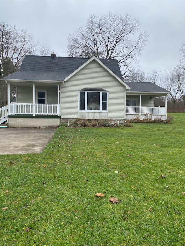 view of front of property with a shingled roof, covered porch, and a front lawn