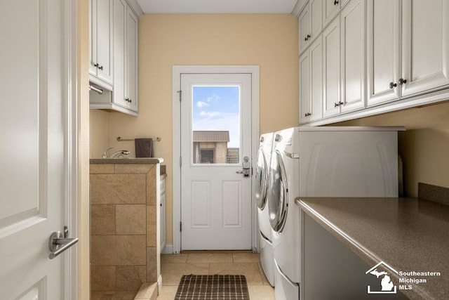 laundry area with washer and dryer, cabinet space, and light tile patterned floors