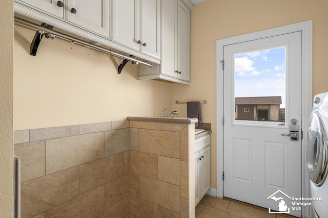 washroom featuring washer / dryer and light tile patterned flooring