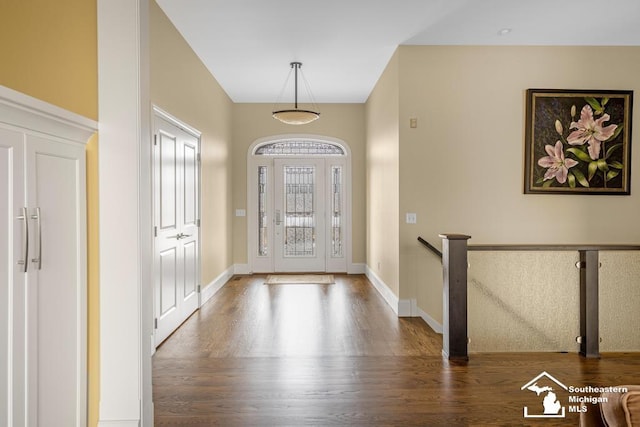 foyer entrance with baseboards and wood finished floors