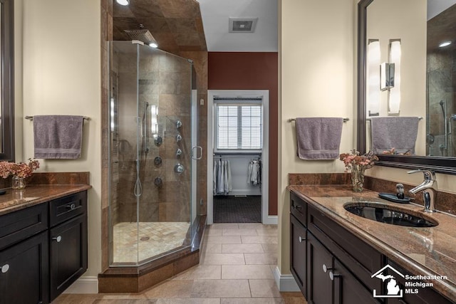 full bath featuring a stall shower, visible vents, baseboards, tile patterned flooring, and vanity