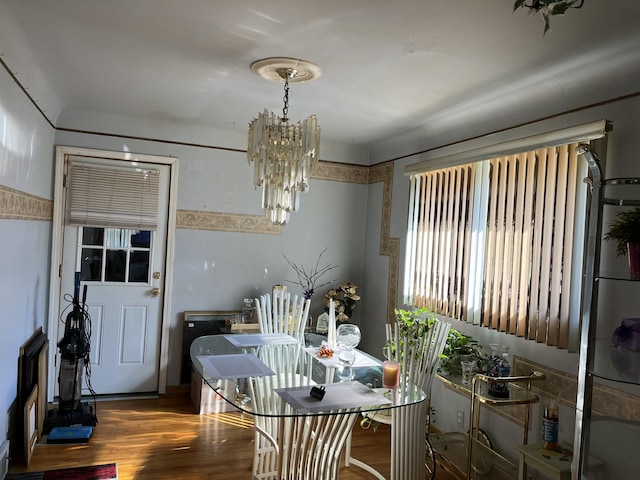 dining area with wood finished floors and a chandelier