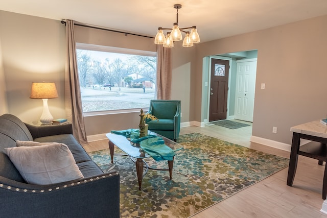 living room featuring wood finished floors, baseboards, and a chandelier