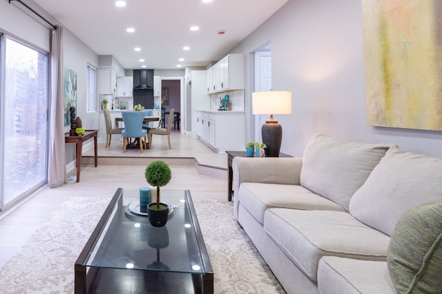 living area featuring recessed lighting, light wood-type flooring, and baseboards