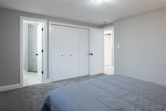 bedroom with a closet, carpet floors, baseboards, and connected bathroom