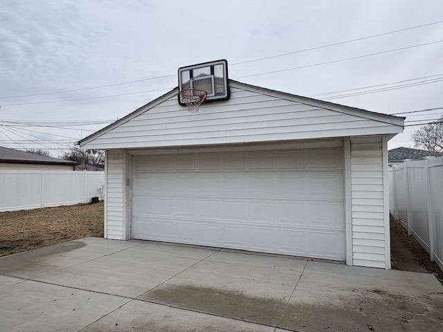 detached garage featuring fence