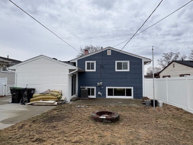 back of house featuring a fire pit, central AC unit, a patio area, and a fenced backyard