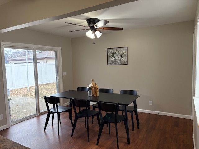 dining area featuring dark wood-style floors, baseboards, and a ceiling fan