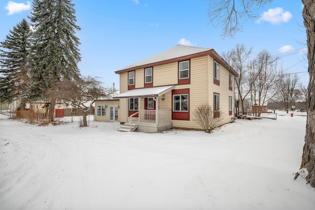 view of snow covered back of property