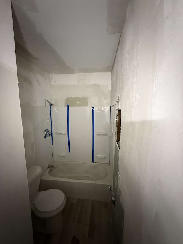 full bathroom with bathtub / shower combination, toilet, and wood finished floors