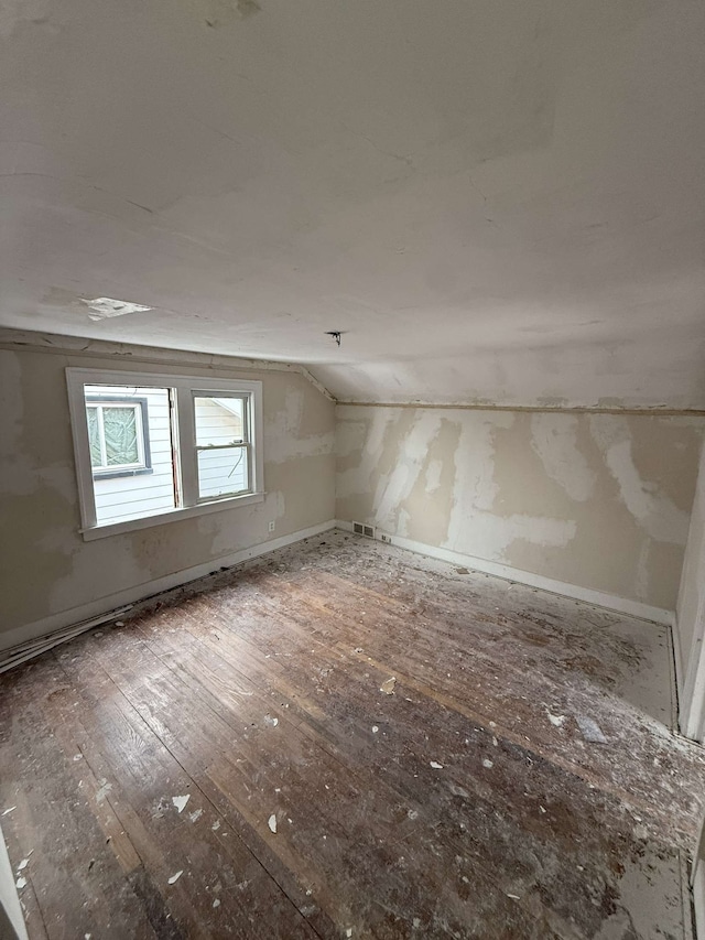 bonus room featuring vaulted ceiling, wood-type flooring, and visible vents