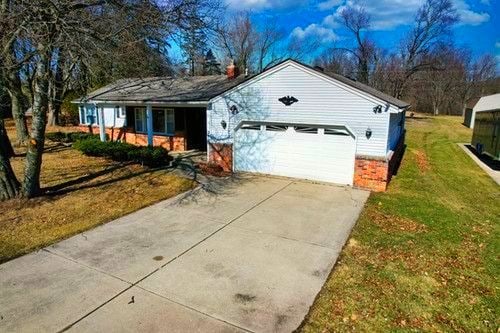 ranch-style house with a garage, a front lawn, and concrete driveway