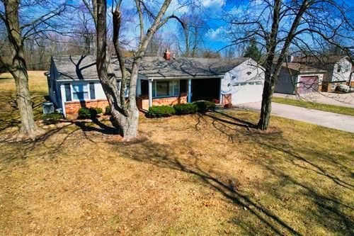 ranch-style house with a front yard and concrete driveway