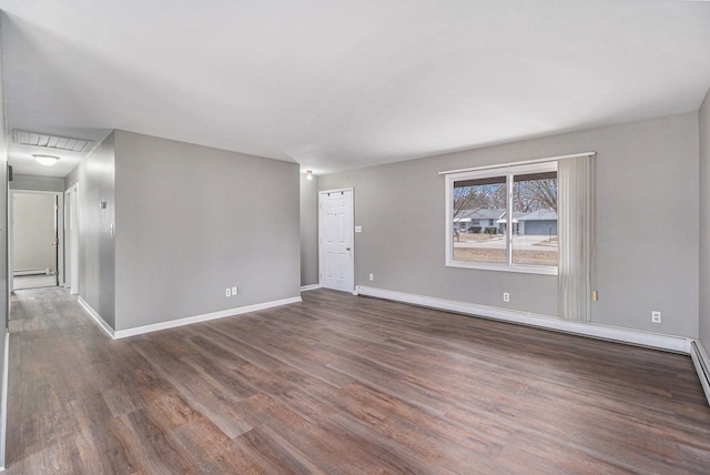 empty room with baseboard heating, baseboards, and wood finished floors