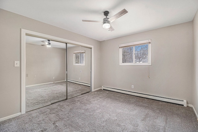 unfurnished bedroom with a baseboard radiator, multiple windows, and carpet