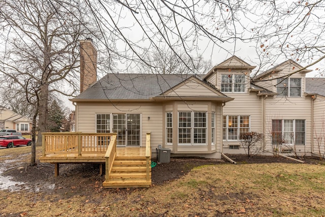 back of house with a chimney and a deck