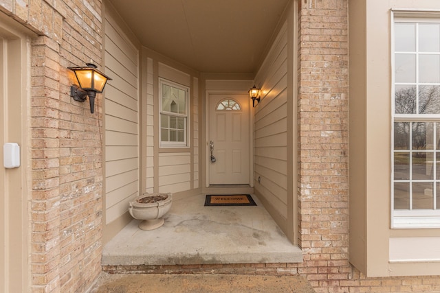 view of exterior entry with brick siding