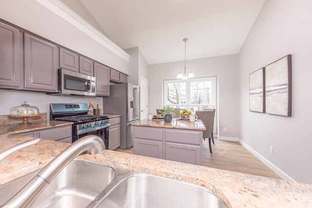 kitchen featuring pendant lighting, lofted ceiling, a notable chandelier, stainless steel appliances, and a sink