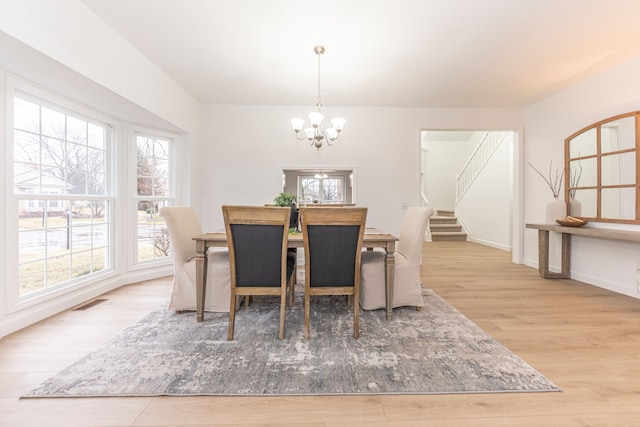 dining room with stairway, a notable chandelier, wood finished floors, and plenty of natural light