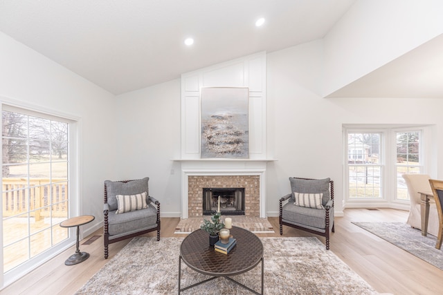 living room featuring a tiled fireplace, recessed lighting, baseboards, and light wood-style floors