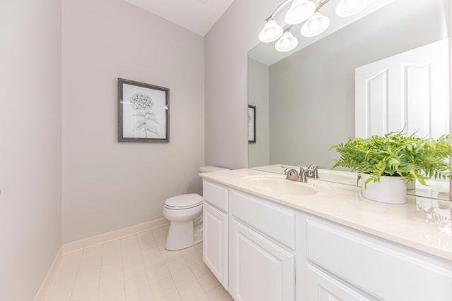 half bathroom featuring tile patterned flooring, toilet, vanity, and baseboards