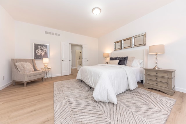 bedroom featuring visible vents, baseboards, and light wood-style floors