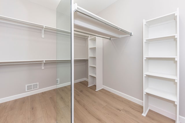 walk in closet featuring visible vents and wood finished floors