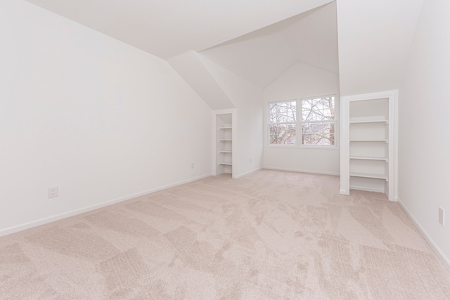 bonus room with vaulted ceiling, built in features, baseboards, and light carpet