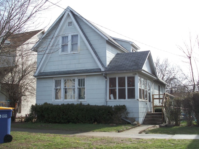 1228 Quarry Ave NW, Grand Rapids, MI 49504 - view of home's exterior featuring a shingled roof and a lawn