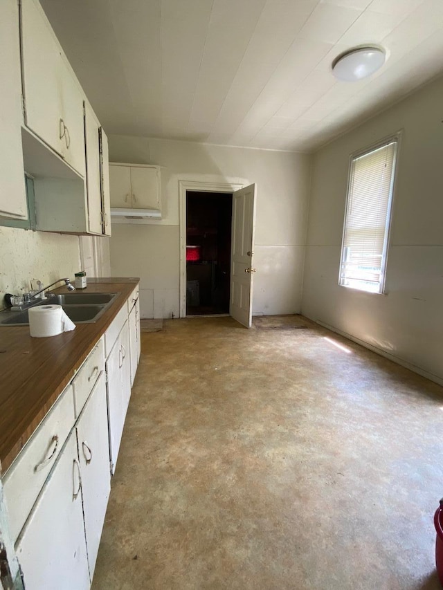 1228 Quarry Ave NW, Grand Rapids, MI 49504 - kitchen featuring dark countertops, concrete floors, and white cabinets